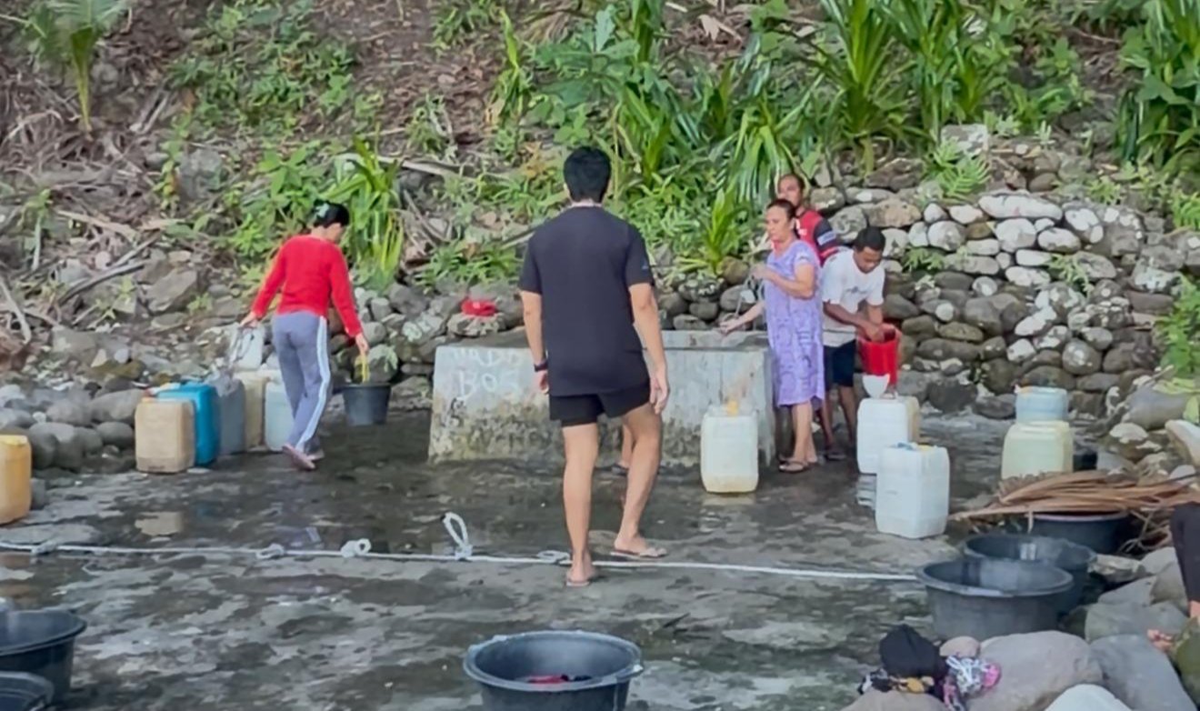 Anggota DPRD Sangihe Tonny Mandak saat memantau warga menimba air sumur di tepi pantai. (Foto: Ist)