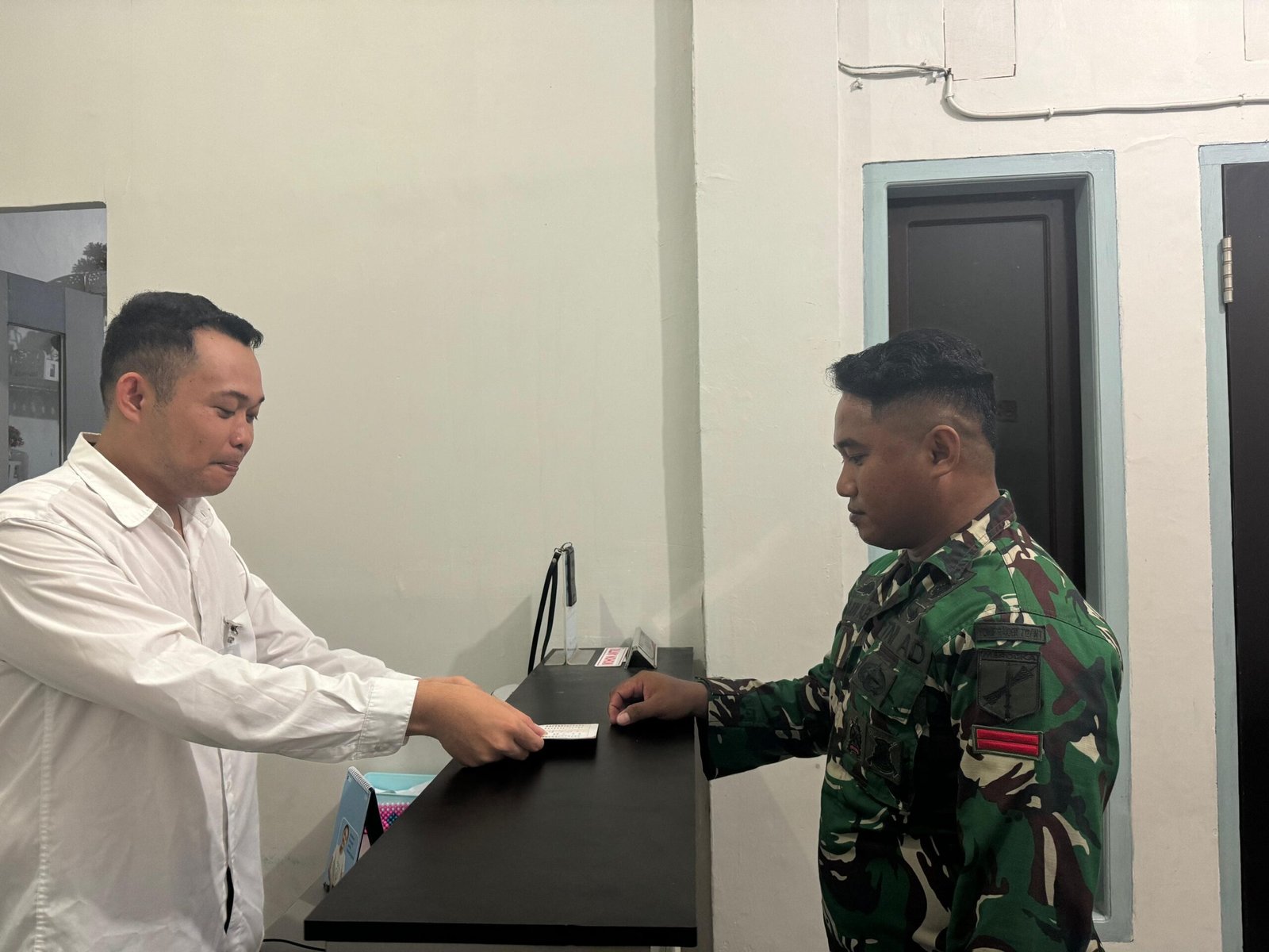 Teller BRI Temporary Outlet Miangas, Stevanus Lumendek, melayani seorang anggota TNI yang sedang menjalankan tugas di Miangas. (Foto: Ist)